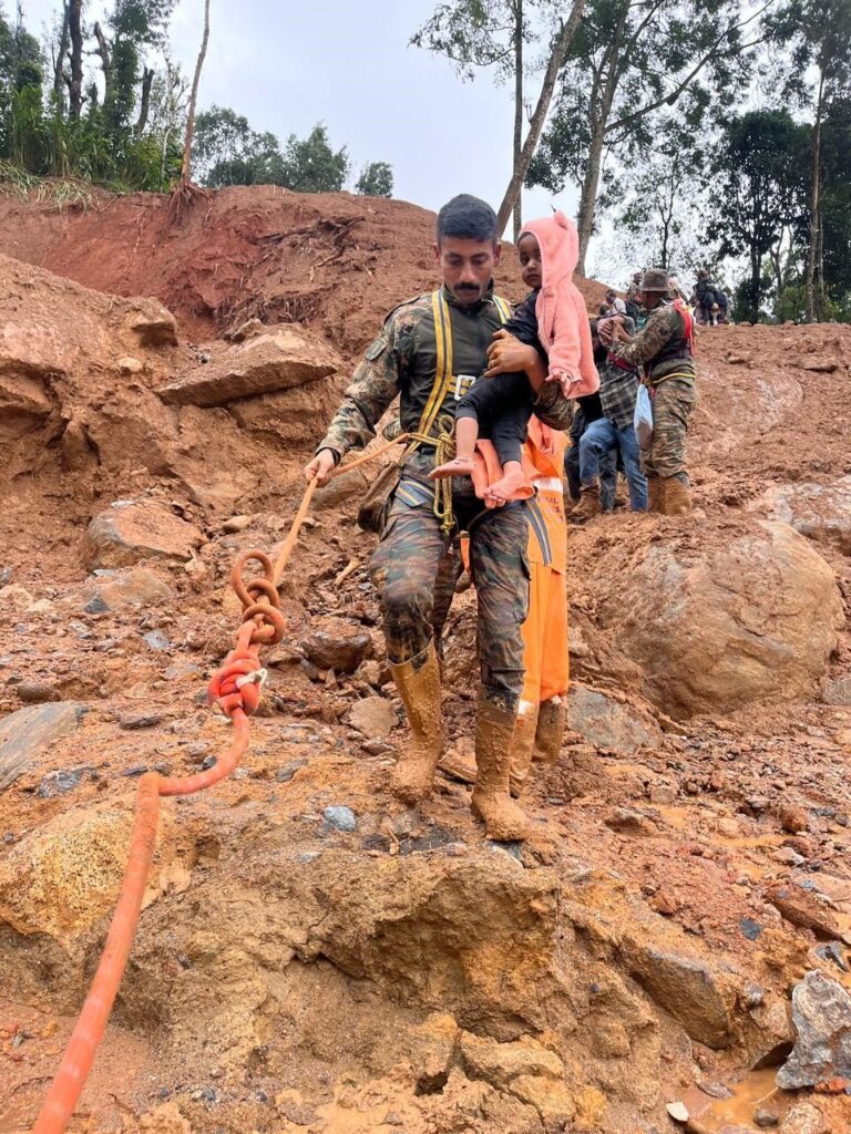 indian army soldier  carrying a child on a rope WAYANAD landslide