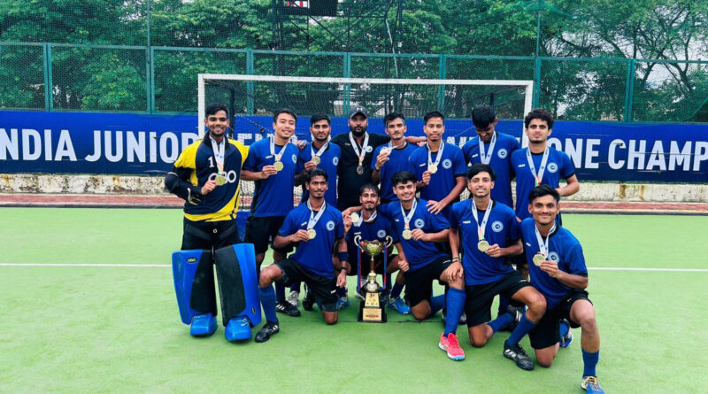 a group of men हॉकी इंडिया in blue uniforms posing with a trophy